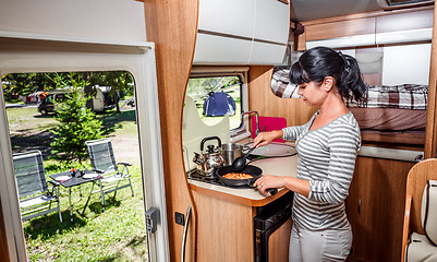 Image showing Woman cooking in camper, motorhome interior