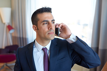 Image showing businessman calling on smartphone at hotel room