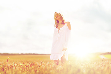 Image showing smiling young woman in white dress on cereal field