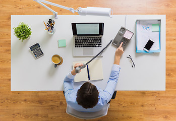 Image showing businesswoman calling on phone at office table