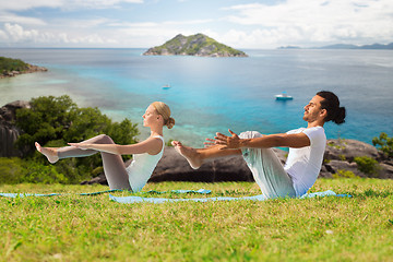 Image showing couple making yoga half-boat pose outdoors