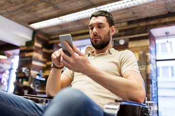 Image showing man with smartphone at barbershop or salon