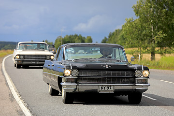 Image showing Black Cadillac Car Cruising on Highway