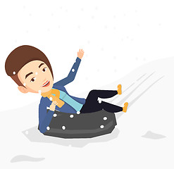 Image showing Woman sledding on snow rubber tube in mountains.