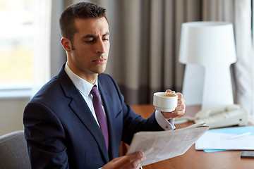 Image showing businessman reading newspaper and drinking coffee