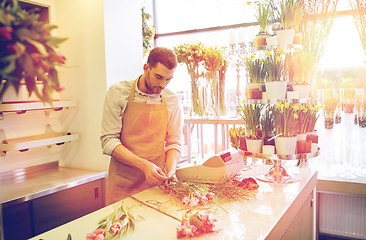 Image showing florist man making bunch at flower shop