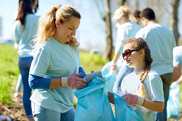 Image showing volunteers with garbage bags cleaning park area