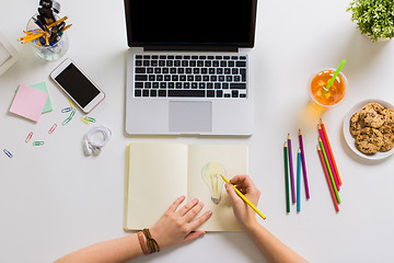 Image showing woman hands drawing in notebook at home office