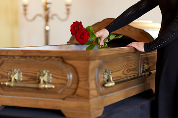 Image showing woman with red roses and coffin at funeral