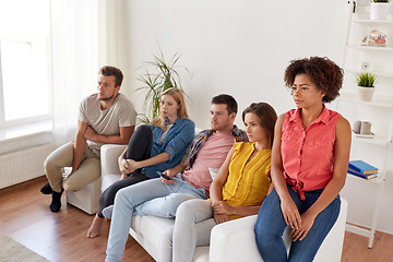 Image showing sad friends watching tv at home