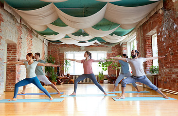 Image showing group of people doing yoga warrior pose at studio