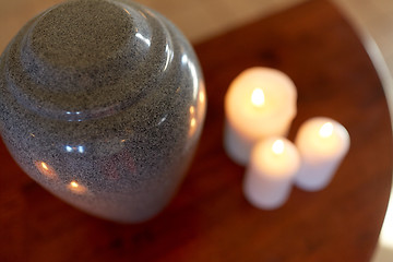 Image showing cremation urn and candles burning on table