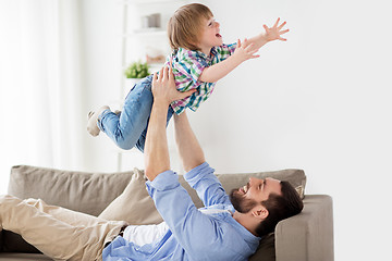 Image showing happy young father playing with little son at home