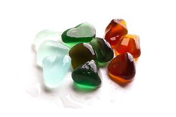 Image showing wet pieces of glass polished by the sea isolated on white