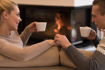 Image showing Young couple  in front of fireplace