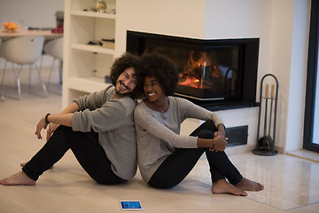 Image showing multiethnic couple with tablet computer on the floor