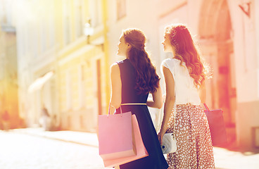 Image showing happy women with shopping bags walking in city 