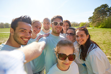Image showing group of volunteers taking selfie by smartphone