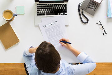 Image showing businesswoman signing contract document at office