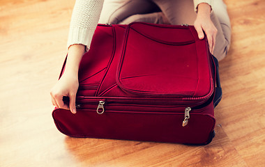 Image showing close up of woman packing travel bag for vacation