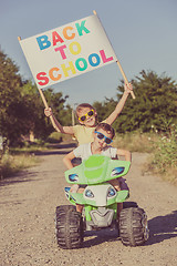 Image showing Happy little children playing on road at the day time. They driv