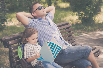 Image showing Father and son playing at the park on bench at the day time.