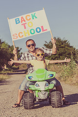 Image showing Father and daughter playing on the road at the day time.