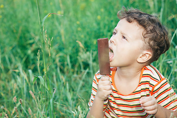 Image showing little boy eating ice cream in the park