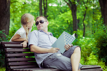 Image showing Father and son playing at the park on bench at the day time.