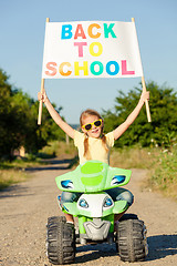 Image showing Happy little girl playing on road at the day time. He driving on