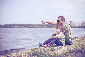 Image showing Father and son playing at the park near lake at the day time.