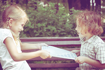 Image showing Two happy children  playing near the tree at the day time.