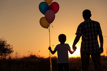 Image showing Father and son playing at the park at the sunset time.