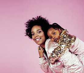 Image showing young pretty african-american mother with little cute daughter hugging, happy smiling on pink background, lifestyle modern people concept