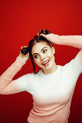 Image showing young pretty emitonal posing teenage girl on bright red background, happy smiling lifestyle people concept closeup