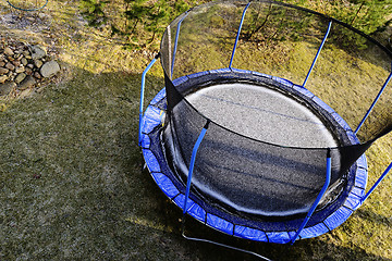 Image showing trampoline on a lawn covered with snow