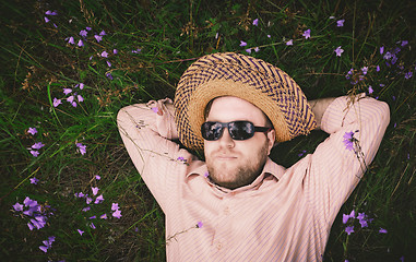 Image showing Man Rest On The Grass And Bellflowers
