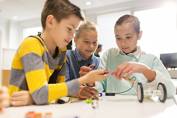 Image showing happy children building robots at robotics school