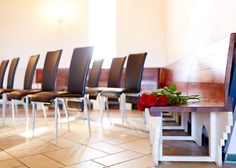 Image showing red roses on bench at funeral in church