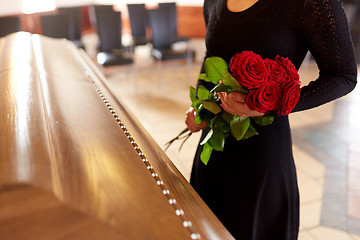 Image showing woman with red roses and coffin at funeral