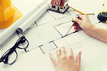 Image showing close up of hands with compass measuring blueprint