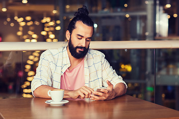 Image showing man with smartphone and coffee at restaurant