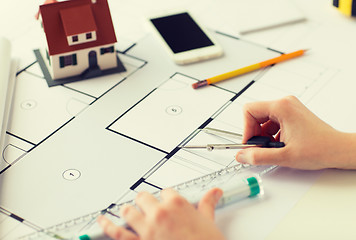 Image showing close up of hands with compass measuring blueprint