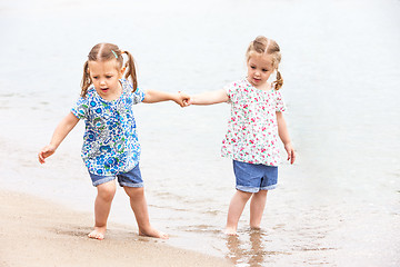 Image showing Children on the sea beach. Twins going along sea water.