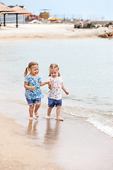 Image showing Children on the sea beach. Twins going along sea water.