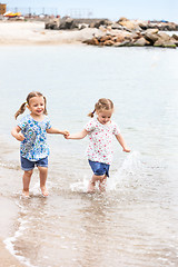 Image showing Children on the sea beach. Twins going along sea water.