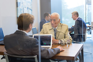 Image showing Financial advisor consulting senior client with his investment strategy.