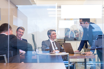 Image showing Relaxed cheerful business people sitting and talking at corporate meeting.