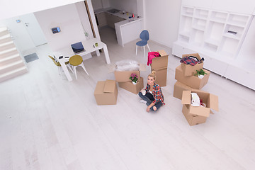 Image showing woman with many cardboard boxes sitting on floor