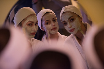 Image showing women putting face masks in the bathroom